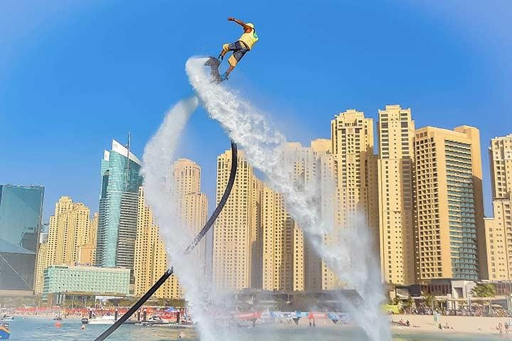 Experience the excitement of flyboarding as you soar above the stunning Dubai Marina taking in breathtaking views and embracing the joy of flight against a backdrop of iconic skyscrapers.